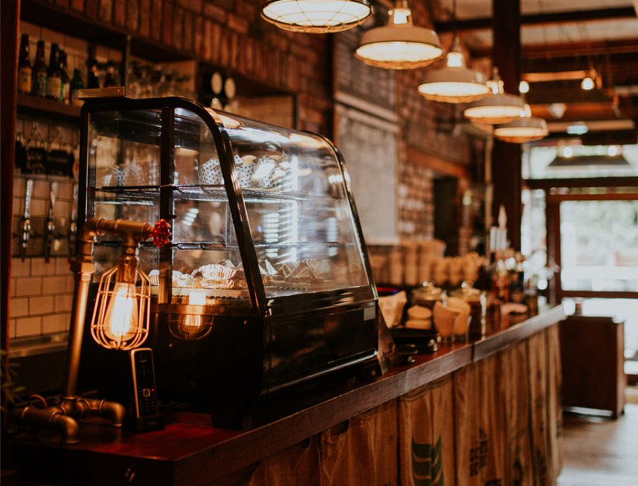 A picture of the restaurant at brewstone with a focus on the cake display and coffee making area