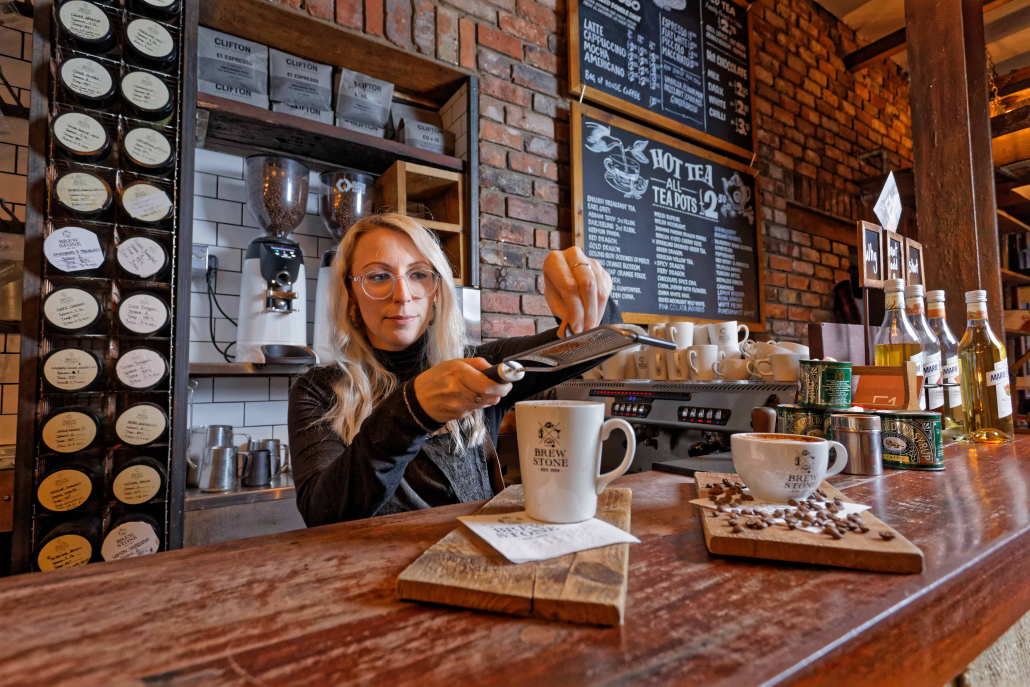 A picture of our barista Becky making hot chocolate and coffee at BrewStone bar and restaurant