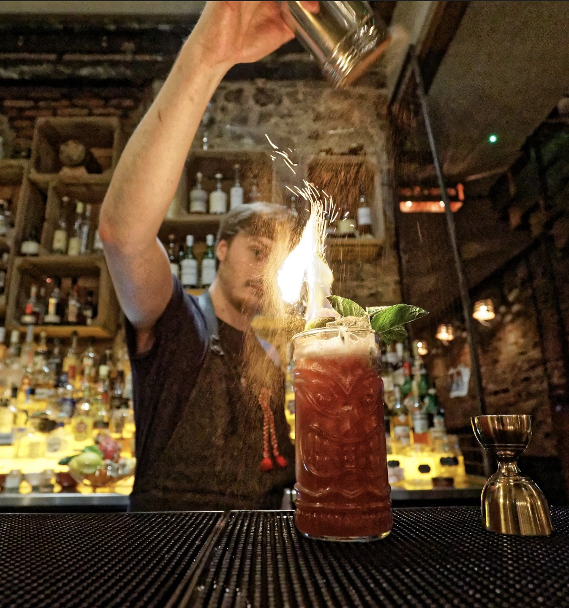 A picture of our bartender making cocktails with fire and rum